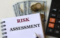 RISK ASSESSMENT - word in a notebook against the background of calculitar and banknotes