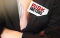 Risk Factor text on the card businessman keeps in his upper suit pocket. Business concept