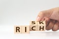 Risk or Rich concept, Hand flip wood cube change the word Royalty Free Stock Photo