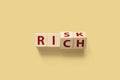 Risk or Rich concept. Wooden cube shape flip change the word