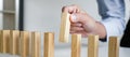 Risk and strategy in business, Close up of business woman hand gambling placing wooden block on a line of domino