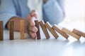 Risk and Strategy in Business, Image of hand stopping falling collapse wooden block dominoes effect from continuous toppled block Royalty Free Stock Photo