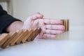 Risk and Strategy in Business, Image of hand stopping falling collapse wooden block dominoes effect from continuous toppled block Royalty Free Stock Photo