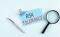 RISK TOLERANCE text written on sticky with magnifier and pen, business concept