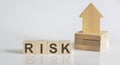 RISK Wooden Blocks With A Miniature House on white background