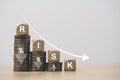 Risk wording on decreasing coins stacking with down arrow for financial banking risk analysis and management ,Low risk low return Royalty Free Stock Photo