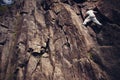 Risky man climbing over danger mountain without rope