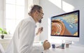 Excited mature man sitting at his computer and trying to win money in an online casino Royalty Free Stock Photo