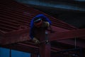 Risky welder while climbing and welding on top of the steel roof structure work at the building construction site. Skilled worker Royalty Free Stock Photo