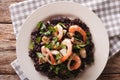 Risotto of black rice with seafood close up on a plate. Horizontal top view Royalty Free Stock Photo