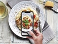 Risotto with mushrooms, tomatoes and basil on plate. Overhead shot by smartphone Royalty Free Stock Photo
