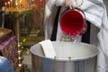 The rite of baptism. Priest prepare to baptize the child. Font for taking faith.Priest pours water into the bath for baptism