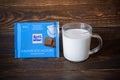 Ritter Sport milk chocolate bar in blue package, glass mug with milk - Saint Petersburg, Russia, August 2020