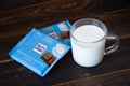 Ritter Sport milk chocolate bars in blue package, glass mug with milk. - Saint Petersburg, Russia, August 2020