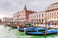 Riva degli Schiavoni, its facades and gondolas with tourists in Venice in Veneto, Italy