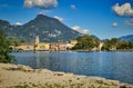 Riva del Garda, Italy- garda lake with Monte Brione, peaks, town, plants, beach, shore, blue sky Royalty Free Stock Photo