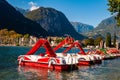 Beautiful Riva del Garda cityscape with vibrant red pedal boats parked in a row on the beach and city surrounded by high dolomite Royalty Free Stock Photo