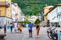 Scenic cityscape of Riva del Garda. Cozy city street full of tourists, plants and Italian architecture with high dolomite