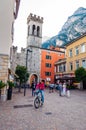 Scenic cityscape of Riva del Garda. Cozy city street full of tourists, plants and Italian architecture with high dolomite