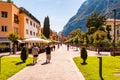 Scenic cityscape of Riva del Garda. Cozy city street full of tourists, plants and Italian architecture with high dolomite