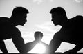 Rivalry, vs, challenge, hand wrestling. Sunset, sunrise. Men measuring forces, arms. Two men arm wrestling. Silhouette Royalty Free Stock Photo