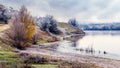 River bank with frost-covered trees, autumn landscape