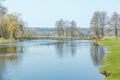 River bank in spring. A small pedestrian bridge across the river Royalty Free Stock Photo