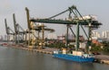 River barge and cranes at port Vict on Song Sai Gon River, Ho Chi Minh City, Vietnam