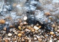 River beach pebbles in waves Royalty Free Stock Photo