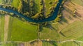 River bend surrounded by fields from bird`s eye view.