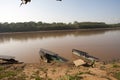 River Boats tied up to pier river bank with view to other shore in Puerto Maldonado in Peru and the Amazon