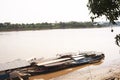 River Boats tied up to pier along river bank with view to other shore in Puerto Maldonado in Peru and the Amazon