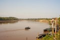 River Boats tied up to pier along river bank with view to other shore in Puerto Maldonado in Peru and the Amazon