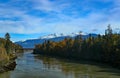 River, bridge and forests with snow capped mountains Royalty Free Stock Photo