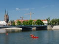 River and bridge view in Wroclaw, Poland. Old church, cranes, kayaks