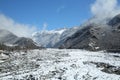 Winter and mountains . There is fog at the foot of the mountains . It snowed on the river stones. In winter, the river