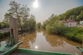 A river with chocolate-colored water with the sun reflecting in it in a foggy sky . Royalty Free Stock Photo