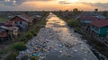 A River Choked by Plastic Waste Amidst Rural Housing at Sunset Royalty Free Stock Photo