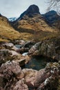River Coe flows through Glen Coe with The Three Sisters mountains in early spring, Scotland Royalty Free Stock Photo