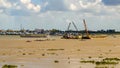 River cranes boats barges sand traffic Cambodia