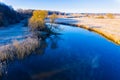 River curve in cold season. Beautiful rural landscape. Sun shining bright in countryside