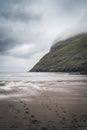 River delta with black sand beach, rocks and high cliffs in Faroe islands, close to village Saksun in Faroese island