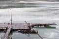 River dock and fishing boat on frozen river during cold winter d Royalty Free Stock Photo