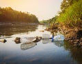 River with Floating Plastic Bottles and Bags Royalty Free Stock Photo