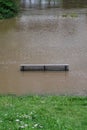 River flood with flooded park bench