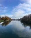 landscape in autumn with river flow with reflections toward building with tower Royalty Free Stock Photo