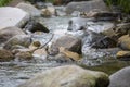 river flow in an unspoiled countryside including clean water and various rocks around it Royalty Free Stock Photo