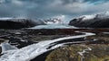 a river next to the mountains under a cloudy sky with snow Royalty Free Stock Photo