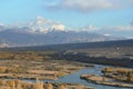 A river flowing through flood plains below snow-capped mountains Royalty Free Stock Photo