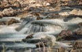 River flowing over rocks cascade on sunny day, closeup detail - long exposure photo Royalty Free Stock Photo